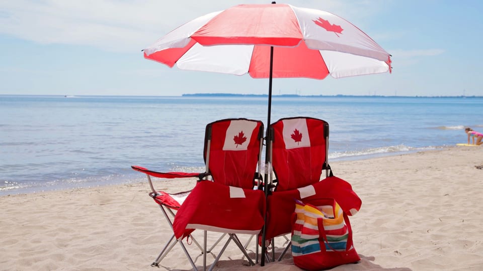Muskoka chairs on the sand facing Lake Erie