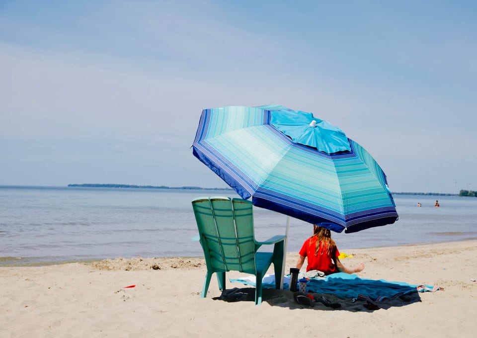 A beach umbrella and chair on the sand at Long Beach Resort