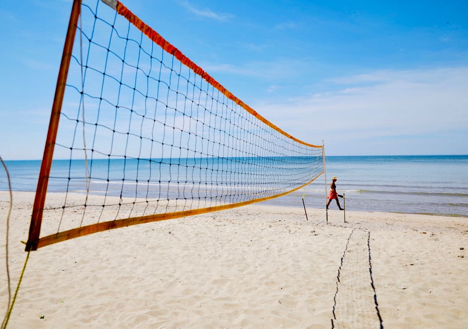 A beach volleyball game on the sand at The Long Beach Resort