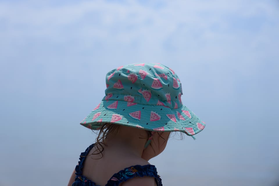 A child in a sun hat on the beach