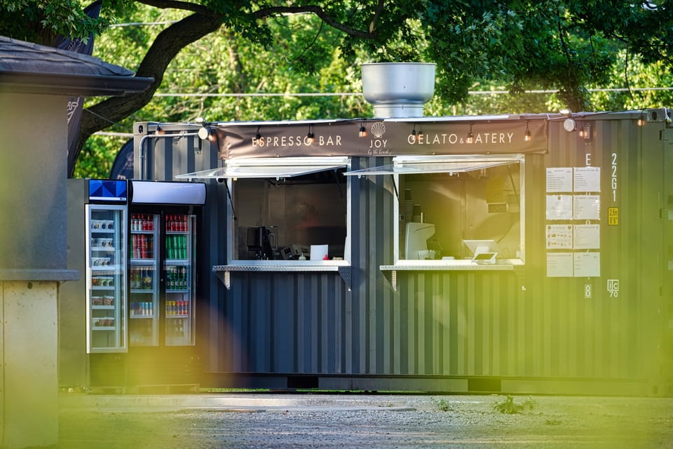 The JOY by the Beach espresso and gelato bar, a clean white shipping-container café