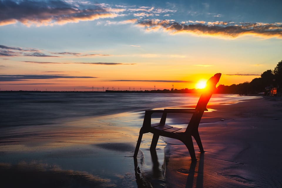 A single beach chair at sunset