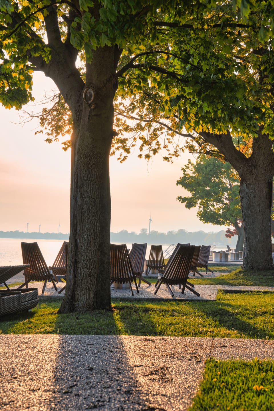 Two chairs facing the water as the sun sets over Lake Erie