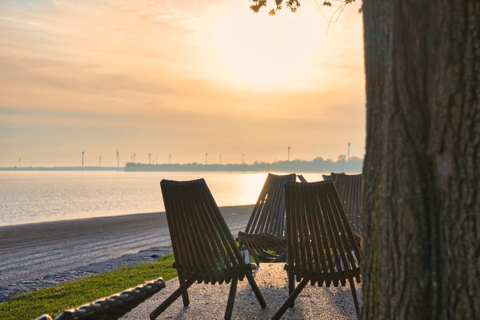 Beach chairs facing the sunset over Lake Erie